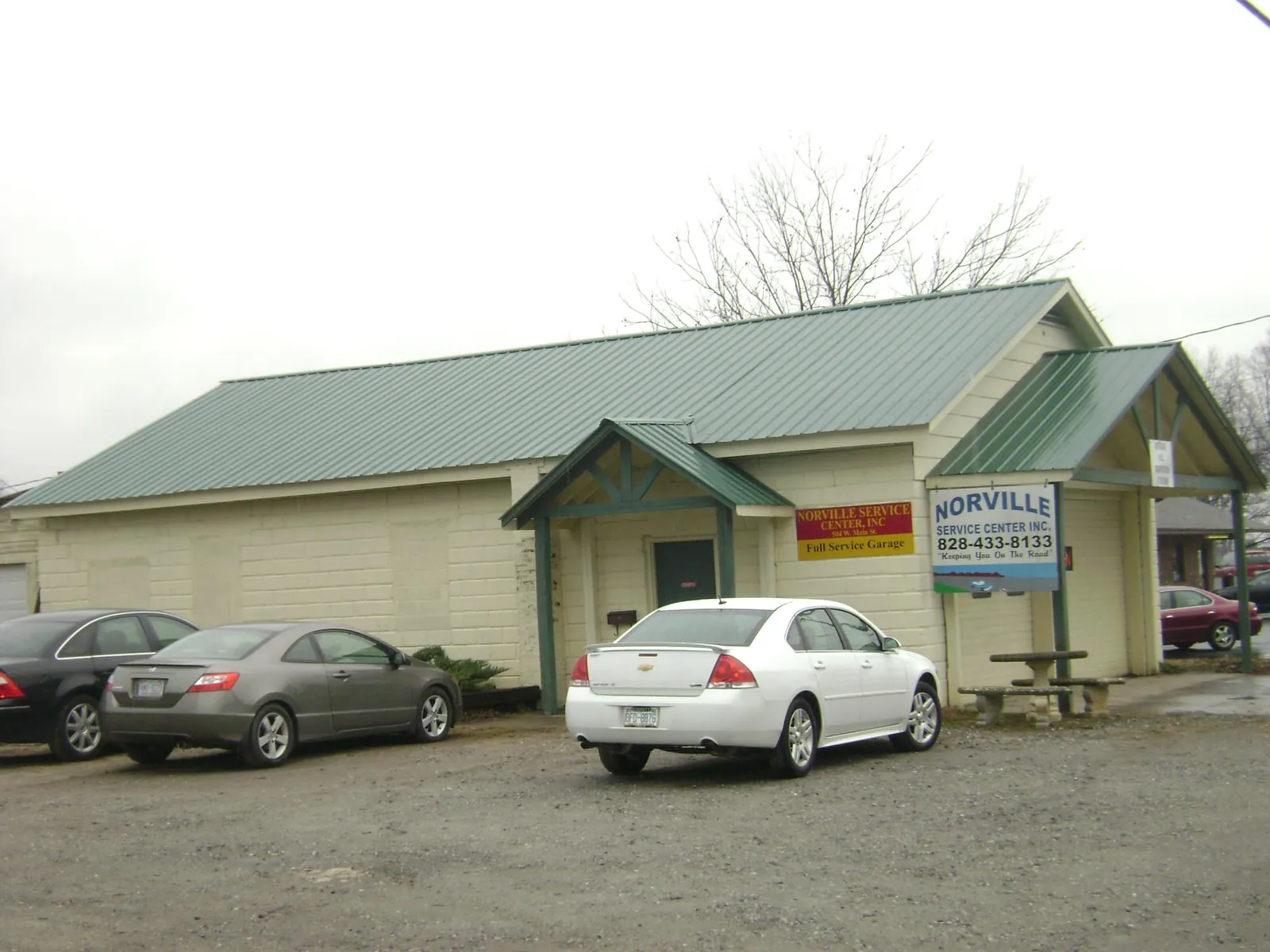 Green metal roof on a service garage with a covered entry in Syracuse